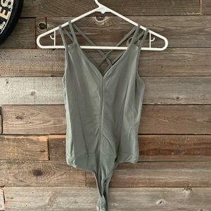 Green bodysuit, thong bottom. Crisscross straps